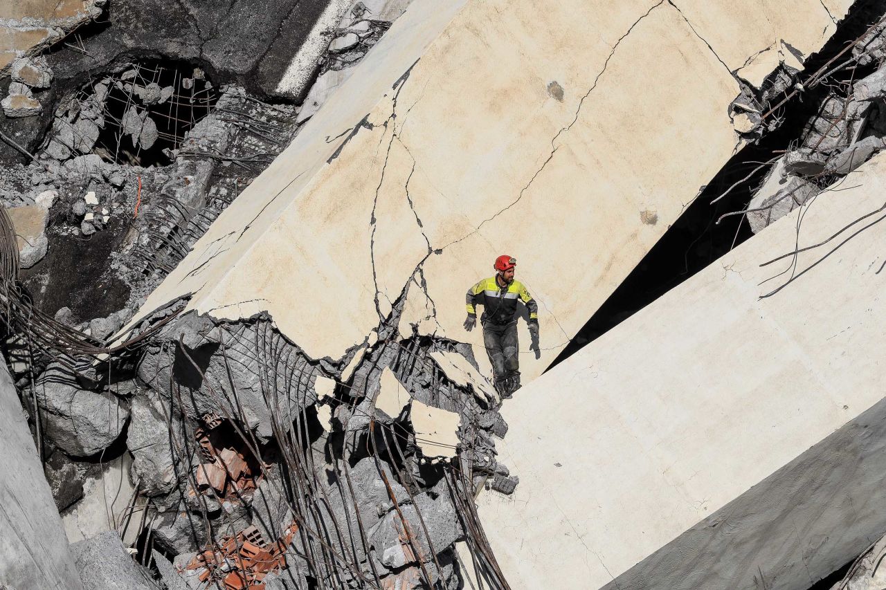 A rescuer climbs through the rubble of the bridge in search of victims and survivors.