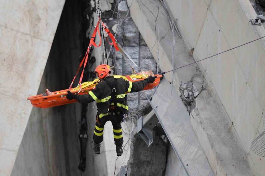 A rescuer and a survivor are lifted from the debris.