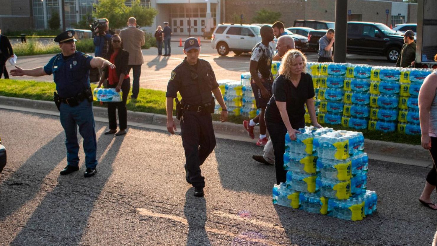 Emergency response teams hand out bottled water to residents at Parchment High School.