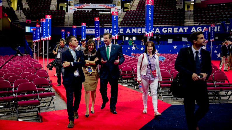 American broadcast journalist Hallie Jackson, (center, left) of NBC TV, walks with Manafort (center, right) and his wife, Kathleen Manafort, on the floor of the Quicken Arena before the Republican National Convention in Cleveland, Ohio, on July 17, 2016. 