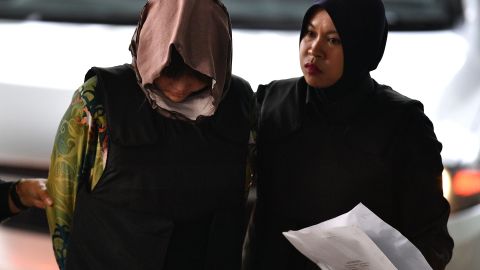 Doan Thi Huong (left) is escorted by Malaysian police to court on Thursday, August 16.