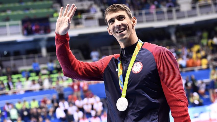 Silver medallist USA's Michael Phelps waves during the medal ceremony of the Men's 100m Butterfly Final during the swimming event at the Rio 2016 Olympic Games at the Olympic Aquatics Stadium in Rio de Janeiro on August 12, 2016.   / AFP PHOTO / CHRISTOPHE SIMON        (Photo credit should read CHRISTOPHE SIMON/AFP/Getty Images)