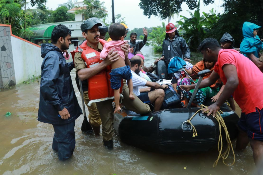 Local residents evacuate from a flooded area in the Kerala city of Kochi on August 15. 