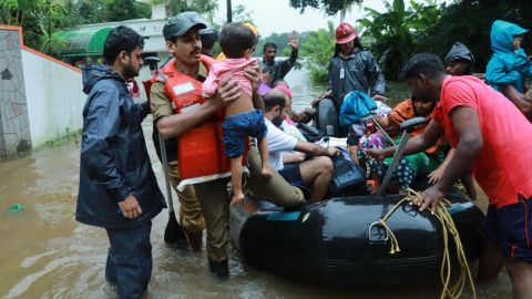Local residents evacuate from a flooded area in the Kerala city of Kochi on August 15.