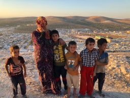 Vaciha Turki Al Omar, 30, has been in Idlib for seven months. She on the hill overlooking the sprawling refugee camp with her kids. "We can try to fight, but the kids are our weakness so we must run away," she says. 
