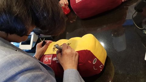 Taiwan President Tsai Ing-wen signs a toy loaf of bread at an 85C bakery in Los Angeles on August 12, 2018.