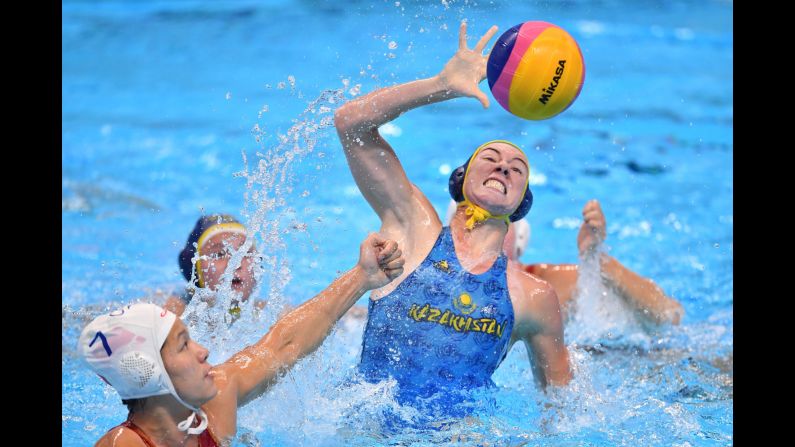 China's Nong Sanfeng, left, has a shot blocked by Uzbekistan's Anna Turova during a water polo match at the Asian Games in Jakarta, Indonesia, on Thursday, August 16.