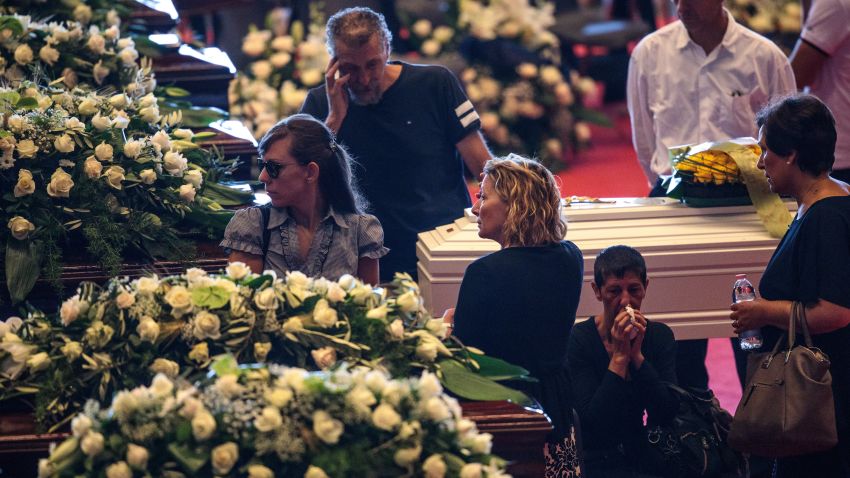 GENOA, ITALY - AUGUST 18: Relatives mourn by coffins of the victims of the Morandi Bridge disaster at the Fiera di Genova exhibition centre ahead of a state funeral service on August 18, 2018 in Genoa, Italy. At least 38 people were killed and five remain missing after a large section of the Morandi highway bridge collapsed on August 14, 2018. (Photo by Jack Taylor/Getty Images)