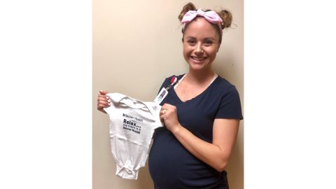 One of the pregnant nurses at Banner Desert Medical Center holds a onesie given to her by the hospital.