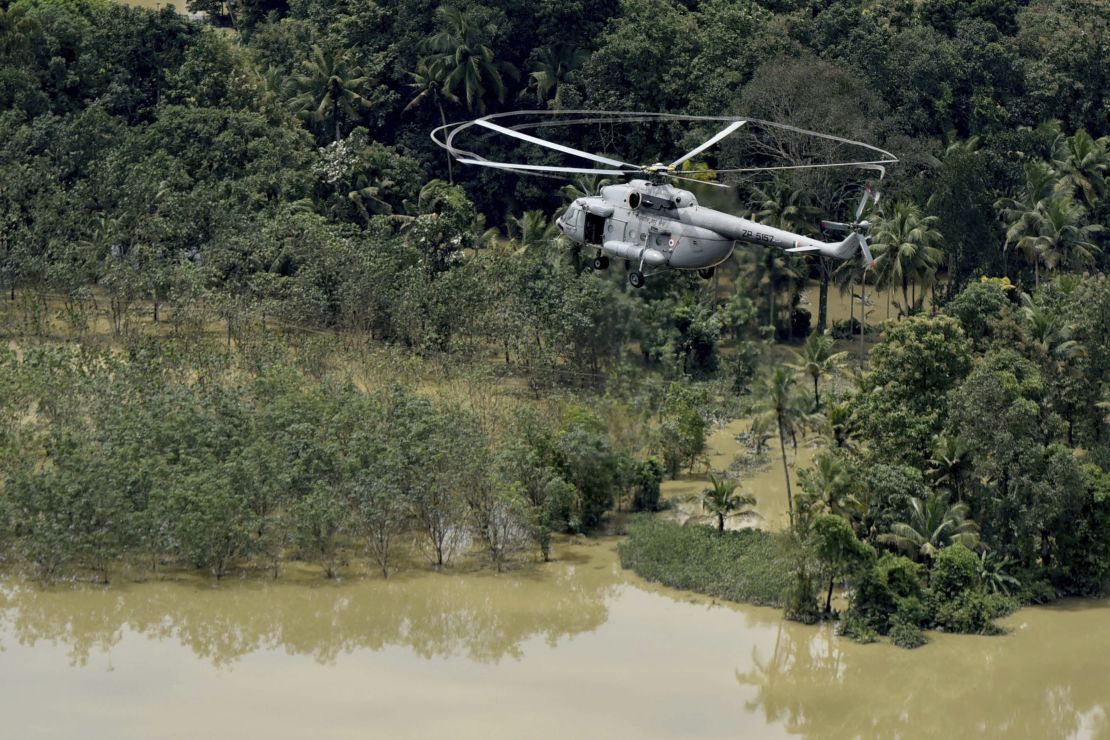 An Indian air-force helicopter on rescue mission flies through a flooded area in Chengannur in the southern state of Kerala on August 19.