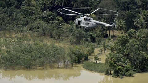 An Indian air-force helicopter on rescue mission flies through a flooded area in Chengannur in the southern state of Kerala on August 19.
