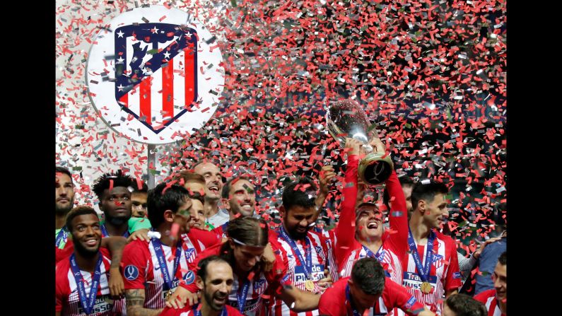 Atlético Madrid's Antoine Griezmann holds up the trophy after his team won the Super Cup on Wednesday, August 15. Atlético Madrid beat Real Madrid 4-2.