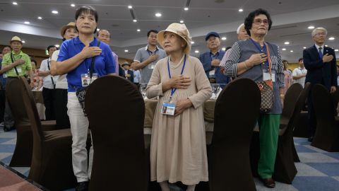 South Korean participants of the inter-Korean family reunions stand for the national anthem as they undergo a briefing on the eve of the departure for North Korea, at a hotel resort in Sokcho on August 19, 2018.