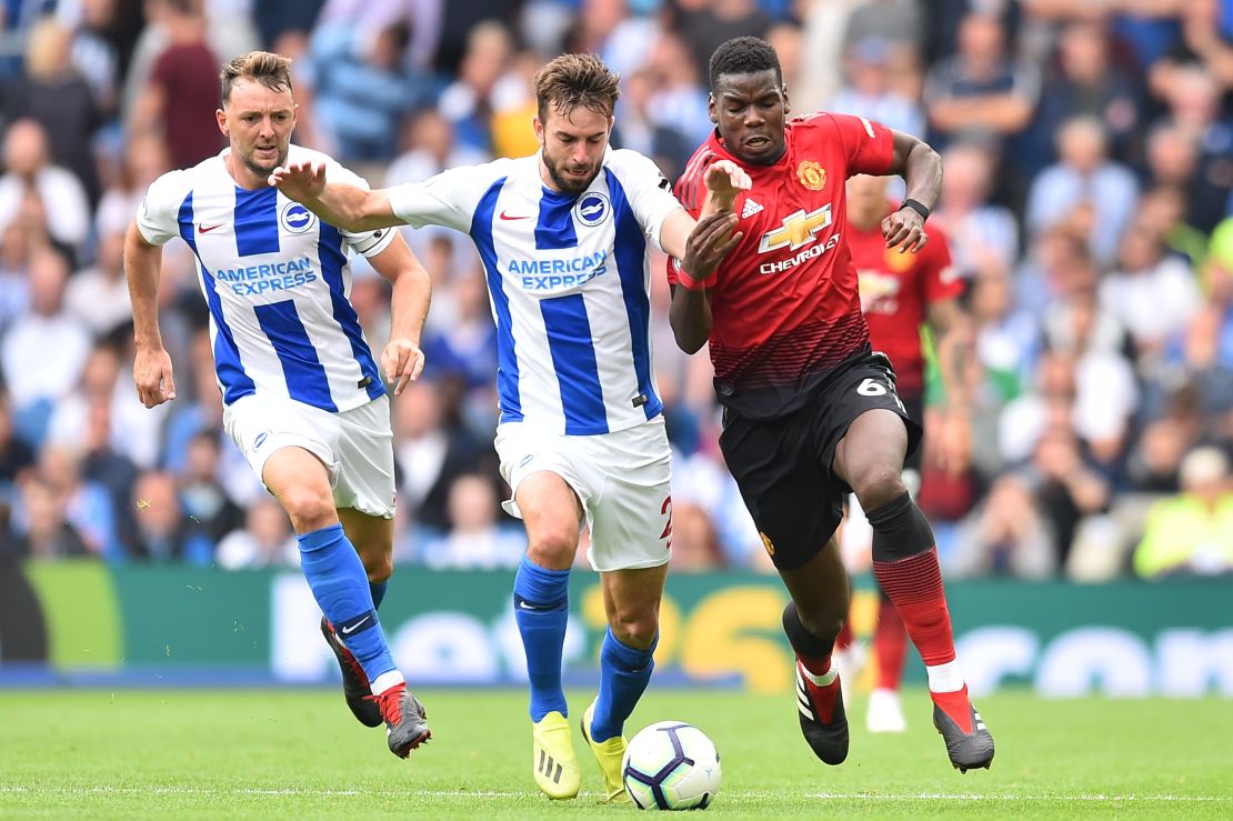 Pogba (R) challenges Brighton's Dutch midfielder Davy Propper (C).