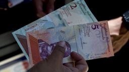 A man shows new five Bolivar-notes in Caracas on August 20, 2018. - Caracas is issuing new banknotes after lopping five zeroes off the crippled bolivar, casting a pall of uncertainty over businesses and consumers across the country. (Photo by Federico PARRA / AFP)        (Photo credit should read FEDERICO PARRA/AFP/Getty Images)