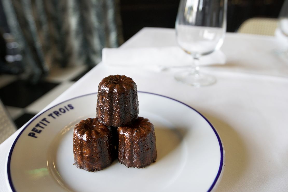 A plate of canelé at Petit Trois. The small French pastry dessert has a soft center and crispy, caramelized exterior.