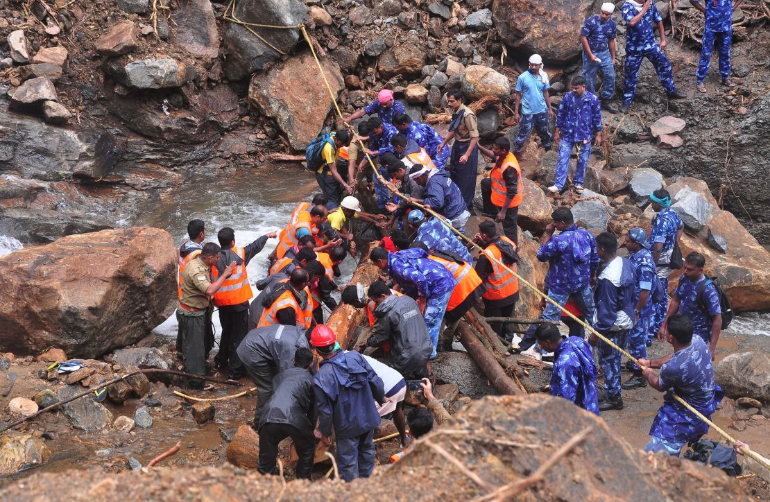 Indian Army personnel and Kerala state police work to build a temporary bridge over a rocky river following heavy flooding in Nelliyampathy in Palakkad district of Kerala.