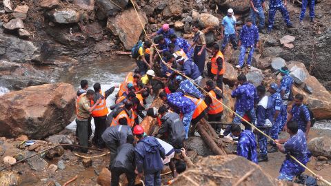 Indian Army personnel and Kerala state police work to build a temporary bridge over a rocky river following heavy flooding in Nelliyampathy in Palakkad district of Kerala.