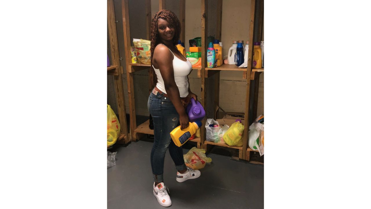 Student Rah-Asia Marrow stocks the shelves with donated laundry detergent for the student laundromat at West Side High School.