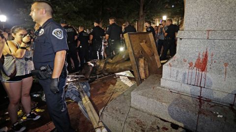 Police stand guard after the confederate statue known as Silent Sam was toppled by protesters.