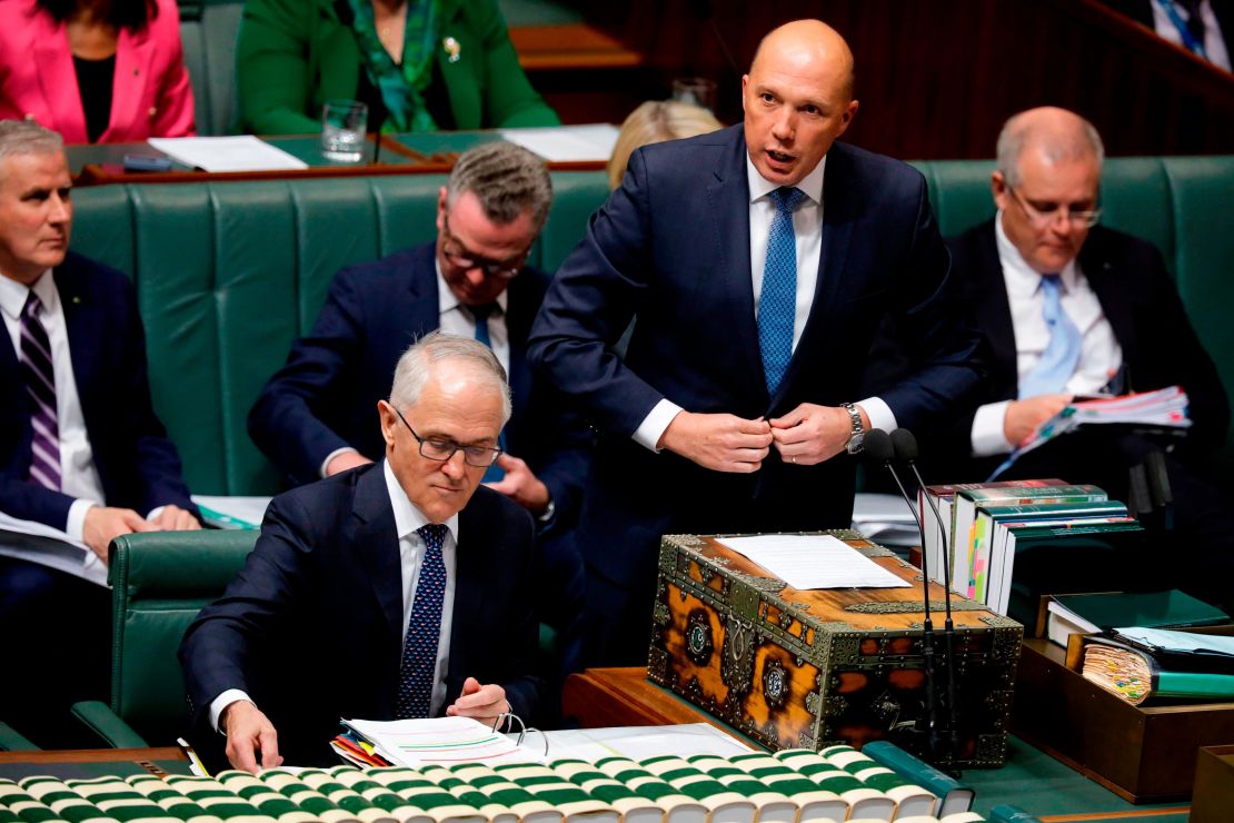 Australia's then-Minister for Home Affairs Peter Dutton (2nd R) speaks at Parliament as Australian Prime Minister Malcolm Turnbull (bottom L) looks at his notes in Canberra on August 20.