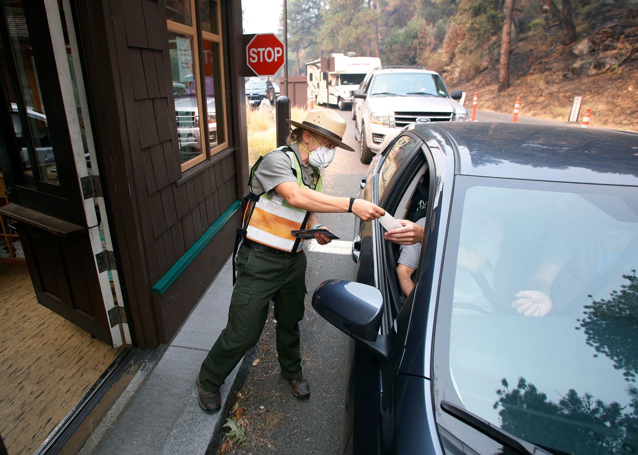 Park Ranger Anne Simmons passes out maps at California's Yosemite National Park  on Tuesday, August 14. The park had been closed for three weeks because of wildfires and smoke.
