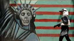 An Iranian woman walks past a mural depicting the Statue of Liberty with a dead face, painted on the wall of the former US embassy in the capital Tehran on August 7, 2018 - US President Donald Trump warned countries against doing business with Iran today as he hailed the "most biting sanctions ever imposed", triggering a mix of anger, fear and defiance in Tehran. (Photo by ATTA KENARE / AFP)        (Photo credit should read ATTA KENARE/AFP/Getty Images)