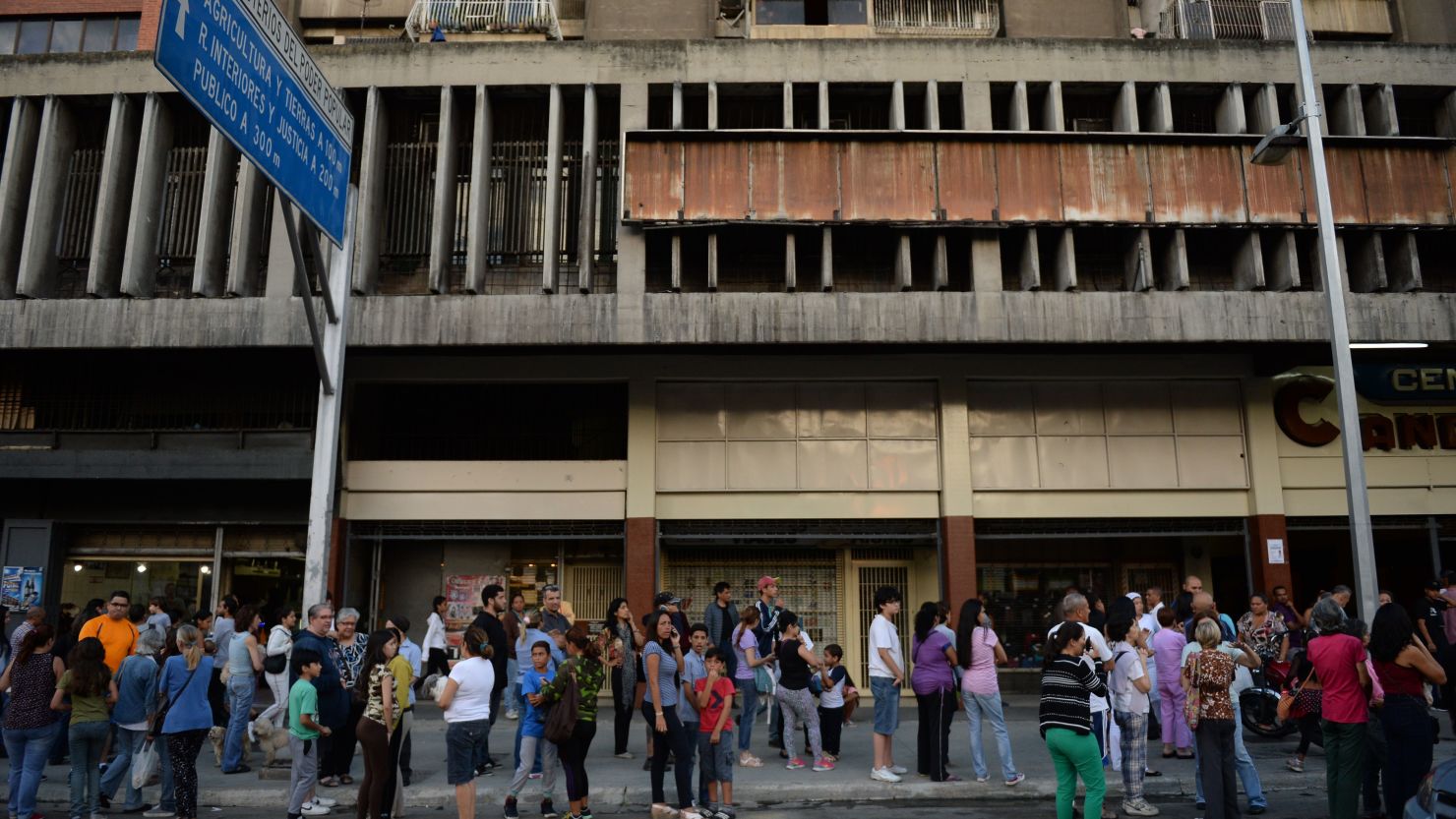 People wait in the streets after evacuating buildings in Caracas on August 21 following an earthquake.