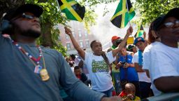 A spectator waves Jamaican flags during the West Indian Day Parade on Monday, Sept. 4, 2017, in the Brooklyn borough of New York. The parade, one of the largest celebrations of Caribbean culture in the U.S., is being held amid ramped-up security. (AP Photo/Kevin Hagen)