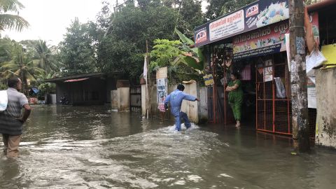 Residents of Venmony in Kerala wait outside their homes and shops for relief.