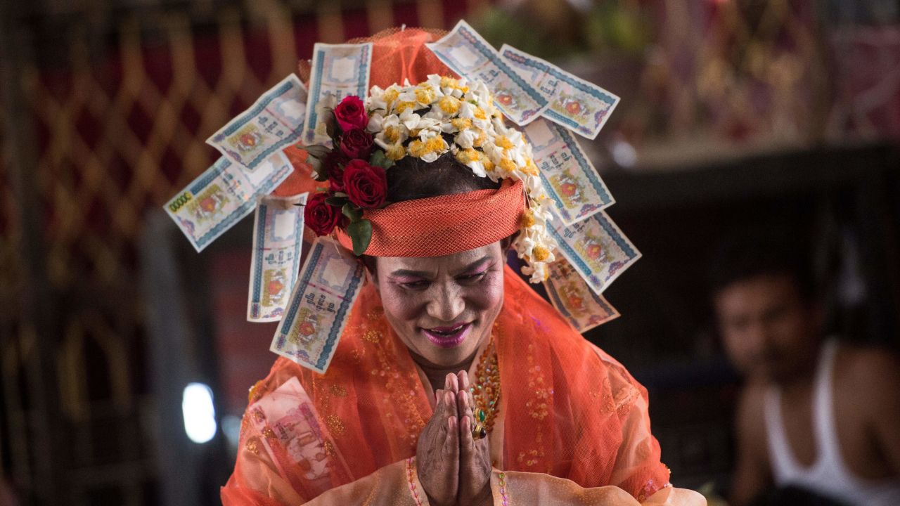 Mediums spin around in a frenzy of red and gold while glugging from a bottle of whiskey, part of an age old ritual to honour Myanmar's spirit guardian of drunkards and gamblers. 