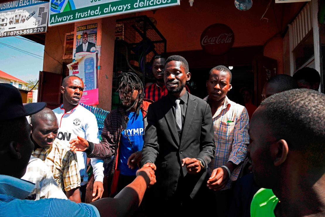 Musician turned politician Robert Kyagulanyi -- commonly known as Bobi Wine -- shakes hands with supporters in a suburb of Kampala on June 30, 2017. 