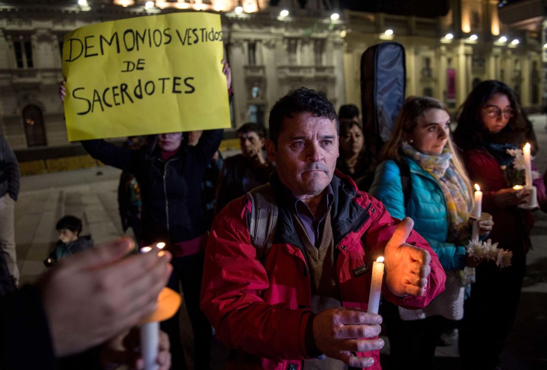 A demonstrator holds a placard reading "Devils Disguised as Priests" during a protest against the sexual abuse scandal in Santiago, Chile.