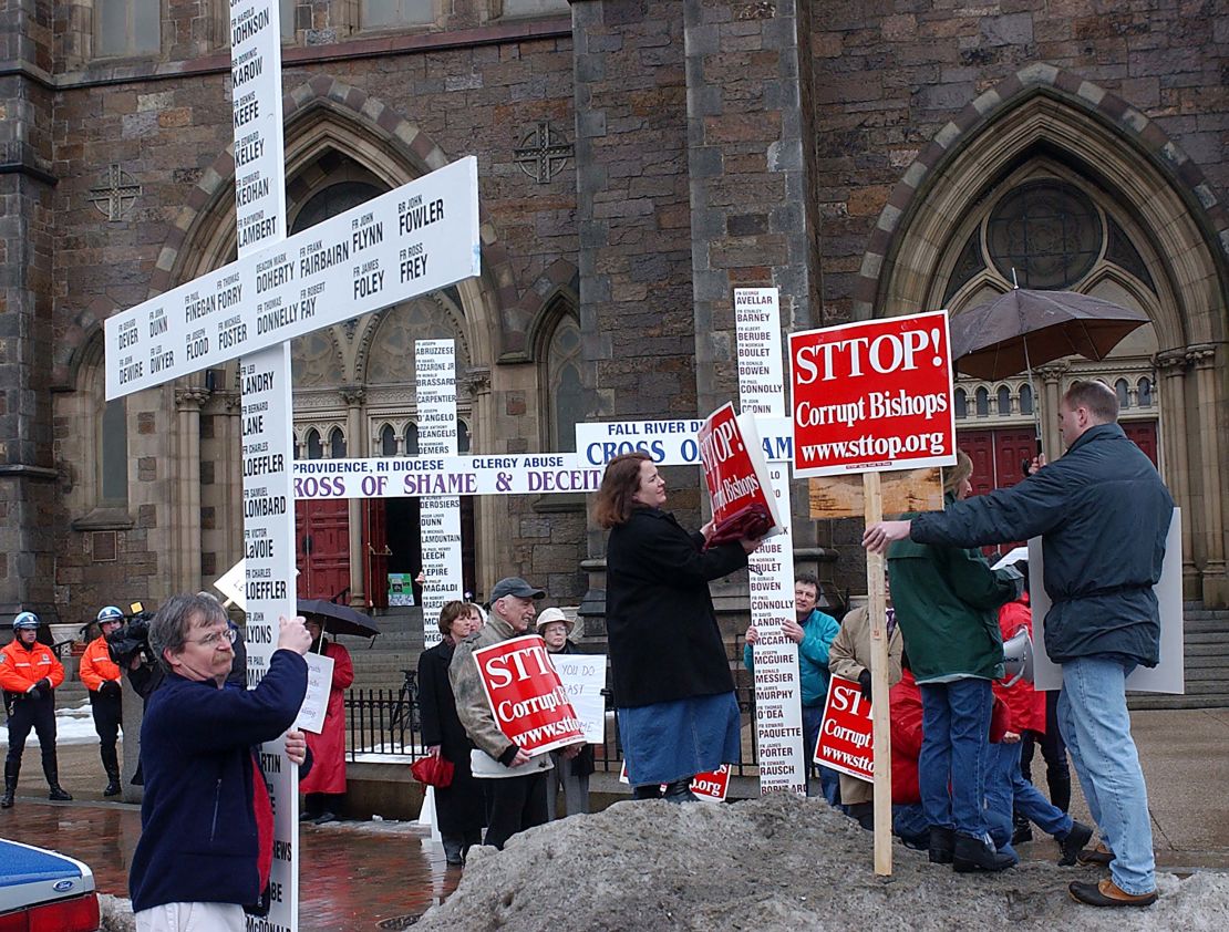 Terry McKiernan (left) at a 2003 protest in Boston carrying a cross with names of Catholic clergy members accused of sexual abuse. 