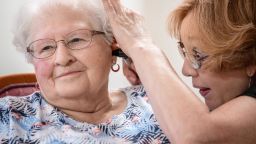 Janie York examines the ear of Elaine Martin at the SilverRidge Assisted Living facility in Gretna, Neb., on Aug. 15, 2018. Martin had "quite a bit" of earwax before getting her ears cleaned by York and getting hearing aids, at her daughter's urging. Now, York keeps Martin's ears clear with regular cleanings. (Chris Machian for KHN)