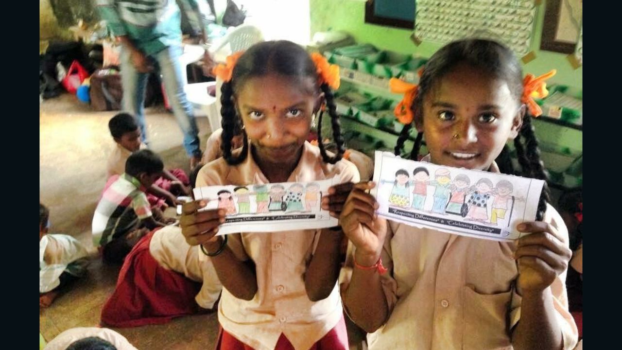 Girls from a Dark is Divine session holding their drawings to celebrate skin tone diversity in Tamil Nadu, India.