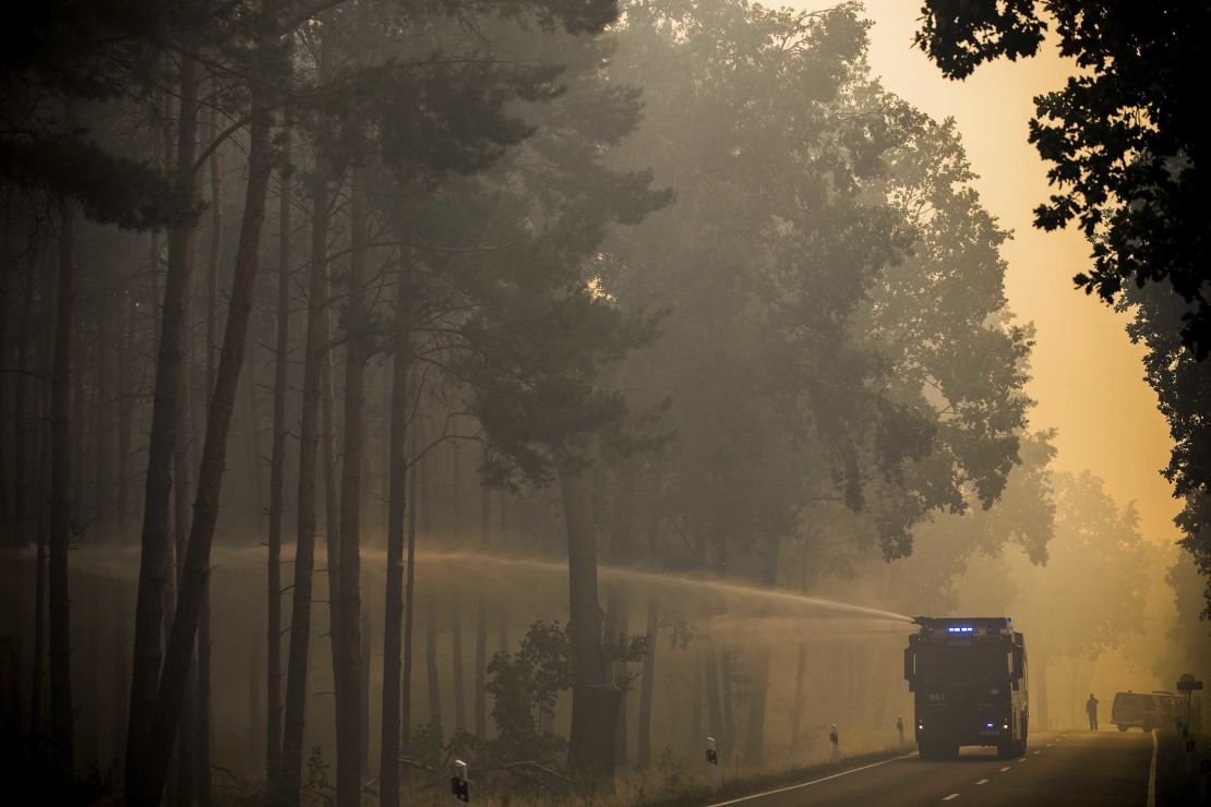 A police water cannon douses a forest near Treuenbrietzen Friday.