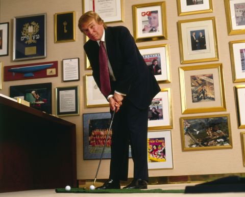 Trump putts a golf ball in his New York office in 1998.