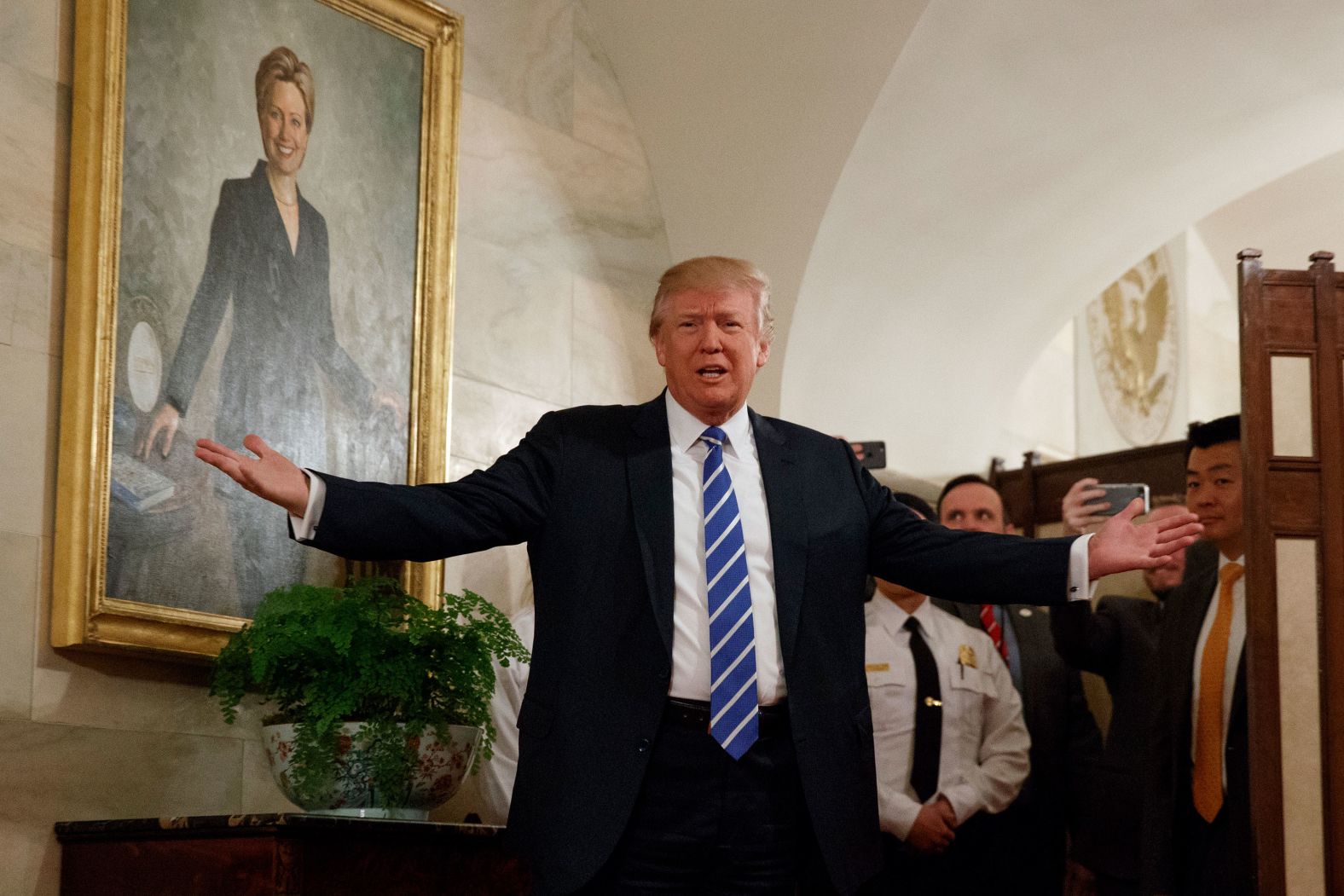 Trump, in front of a portrait of his 2016 opponent Hillary Clinton, <a href="index.php?page=&url=http%3A%2F%2Fwww.cnn.com%2F2017%2F03%2F07%2Fpolitics%2Ftrump-white-house-tour-surprise%2F" target="_blank">surprises visitors</a> who were touring the White House in March 2017. The tour group, including many young children, cheered and screamed after the president popped out from behind a room divider.