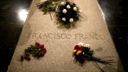 Flower are placed on the tomb of former Spanish dictator Francisco Franco inside the basilica at the the Valley of the Fallen monument near El Escorial, outside Madrid, Friday, Aug. 24, 2018. Spain's center-left government has approved legal amendments that it says will ensure the remains of former dictator Gen. Francisco Franco can soon be dug up and removed from a controversial mausoleum. (AP Photo/Andrea Comas)