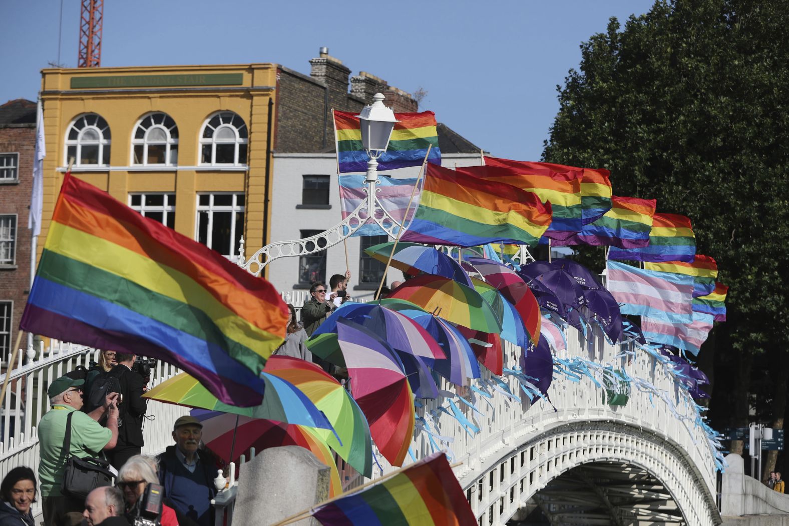 Rainbow flags and blue ribbons are tied to Ha'penny Bridge in Dublin to remember the victims of Catholic Church clerical sex abuse.