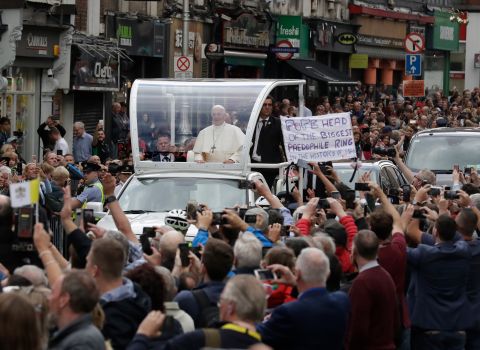 Pope Francis passes by a banner of a protester as he leaves St. Mary's Pro-Cathedral in Dublin on Saturday. The Pope spoke of his shame over the "appalling crimes" of historic child abuse in the Catholic Church and said outrage was justified. However, he failed to specifically mention the current scandal over a US grand jury report documenting at least 1,000 cases of clerical pedophilia.