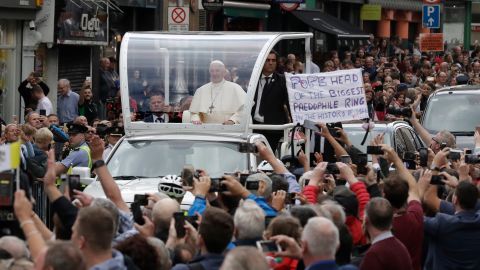 Pope Francis passes a protest banner after visiting St Mary's Pro-Cathedral in Dublin on Saturday.