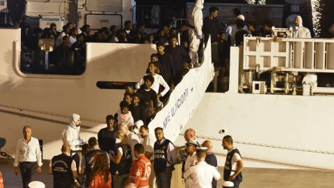 Migrants disembark an Italian Coast Guard ship in the port of Catania, Sicily, early Sunday morning.