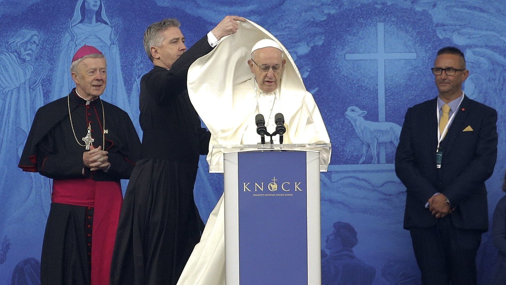 An aide adjusts Pope Francis' cape as he speaks at the Knock Shrine in Knock, Ireland, on Sunday.