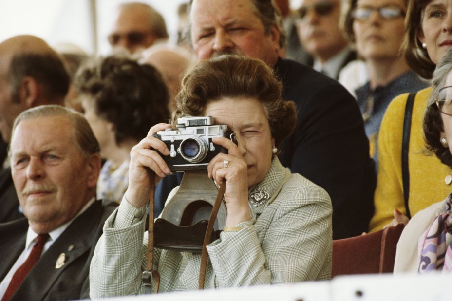 Elizabeth takes pictures of her husband during a horse show in Windsor in May 1982.