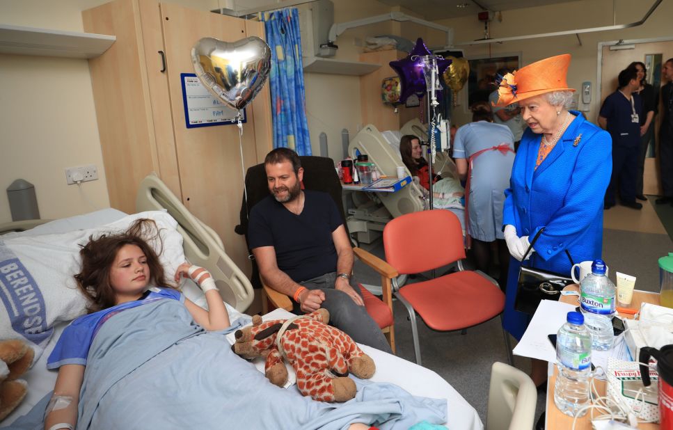 Elizabeth speaks to Evie Mills, 14, at a hospital in Manchester, England, in May 2017. Evie was injured in a bombing that took place as people left an Ariana Grande concert.