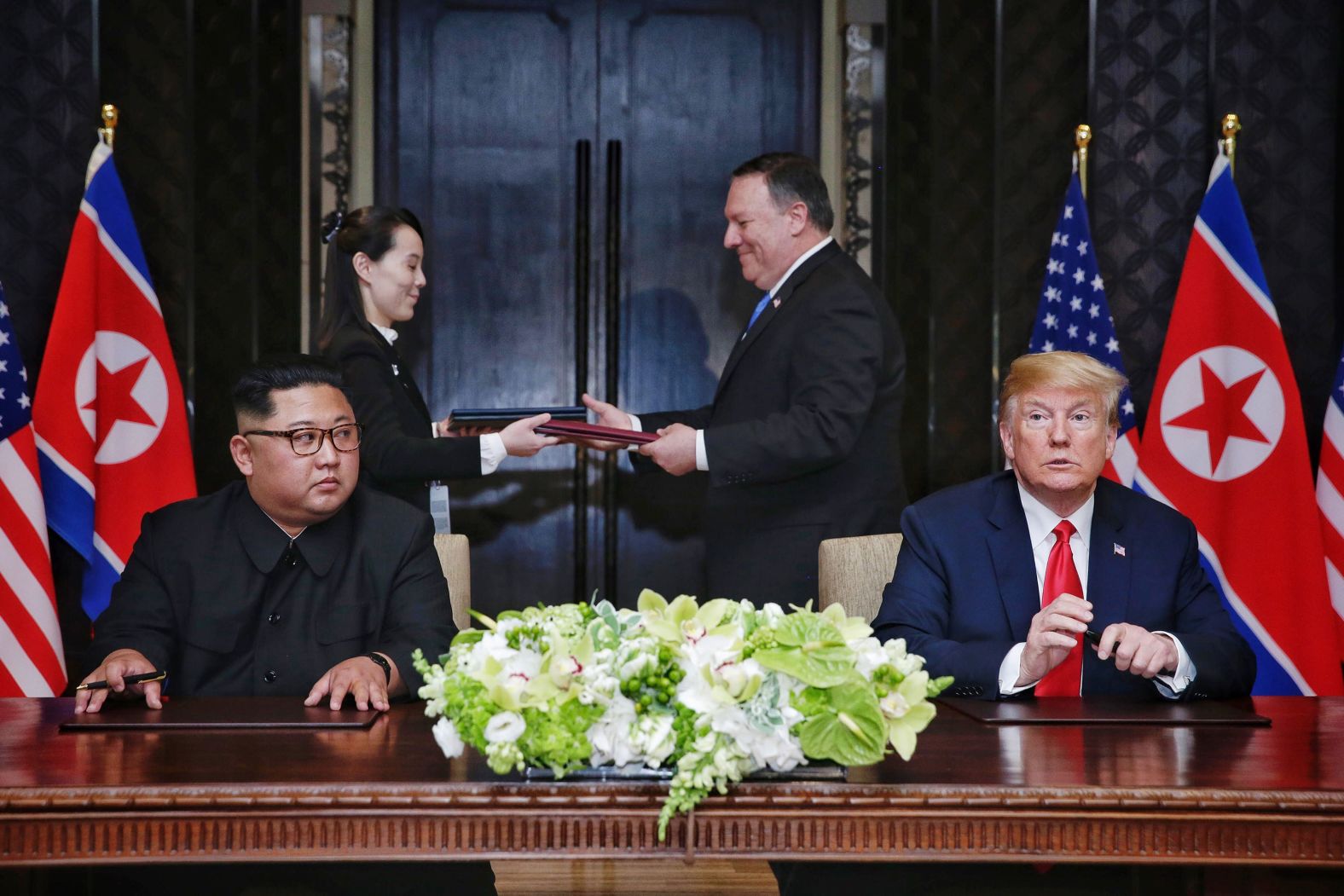 Trump sits with North Korean leader Kim Jong Un during <a href="index.php?page=&url=https%3A%2F%2Fwww.cnn.com%2Finteractive%2F2018%2F06%2Fpolitics%2Ftrump-kim-summit-cnnphotos%2Findex.html" target="_blank">their historic summit in Singapore</a> in June 2018. It was the first meeting ever between a sitting US president and a North Korean leader. At the end of the summit, they signed a document in which they agreed "to work toward complete denuclearization of the Korean Peninsula." In exchange, Trump agreed to "provide security guarantees" to North Korea.
