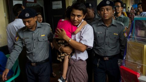 Detained Myanmar journalist Kyaw Soe Oo hugs his daughter as he is escorted by police to a courtroom for his on going trial in Yangon on July 17, 2018.