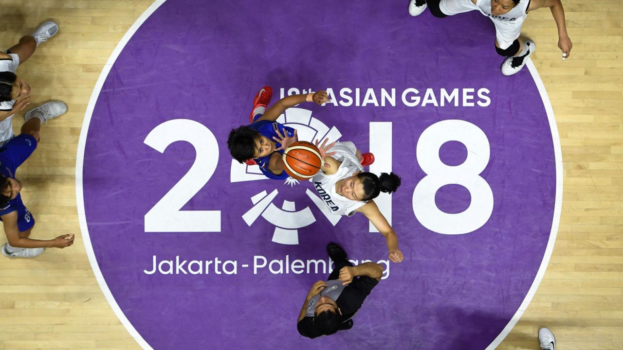 Unified Korea's Ro Suk Yong and Thailand's Kanokwan Prajuapsook go up for the jump ball during the women's basketball quarter-final match between Thailand and Unified Korea.